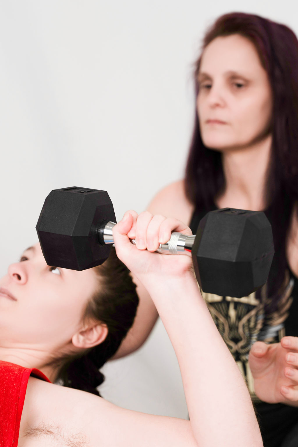Denise spotting a client on a dumbbell bench press