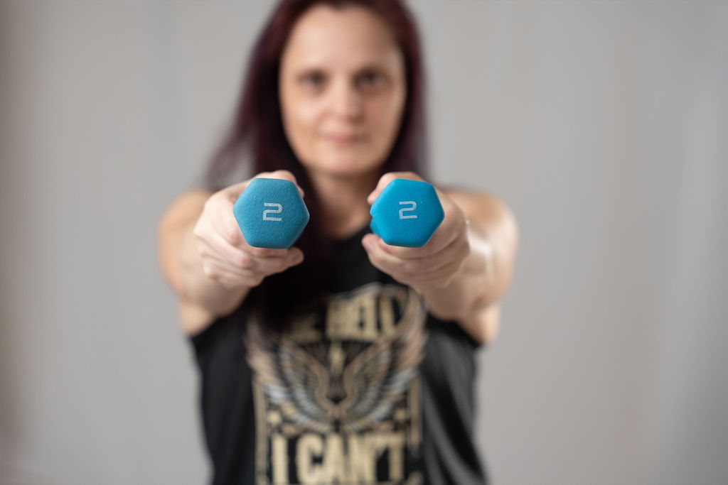 Denise holding two-pound dumbbells, ready to start